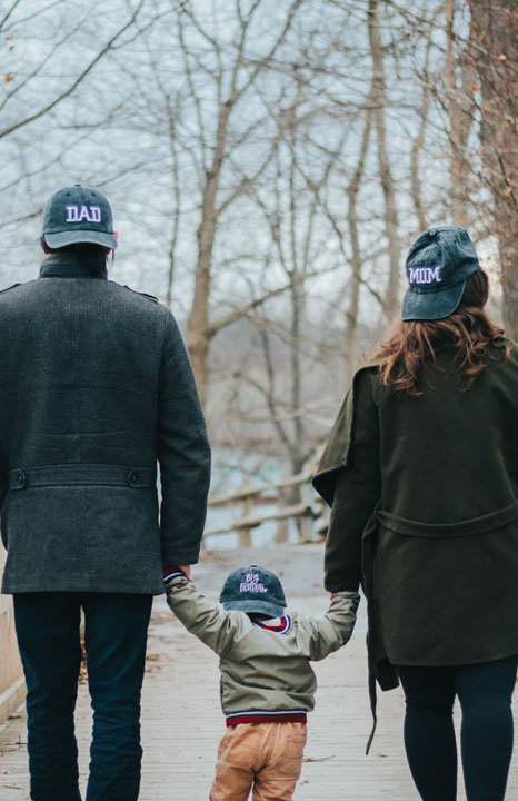 Family holding hands with their toddler.