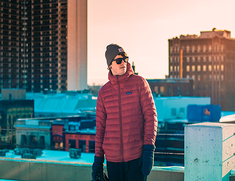 Guy in the winter standing in front of city scape.
