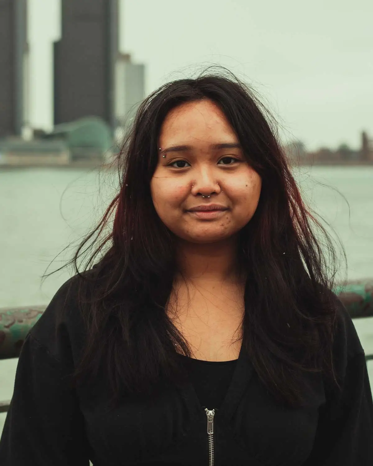 Woman posing for photograph outside.