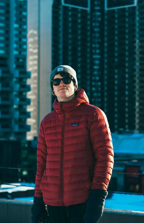 Man in winter coat smiling at camera in winter