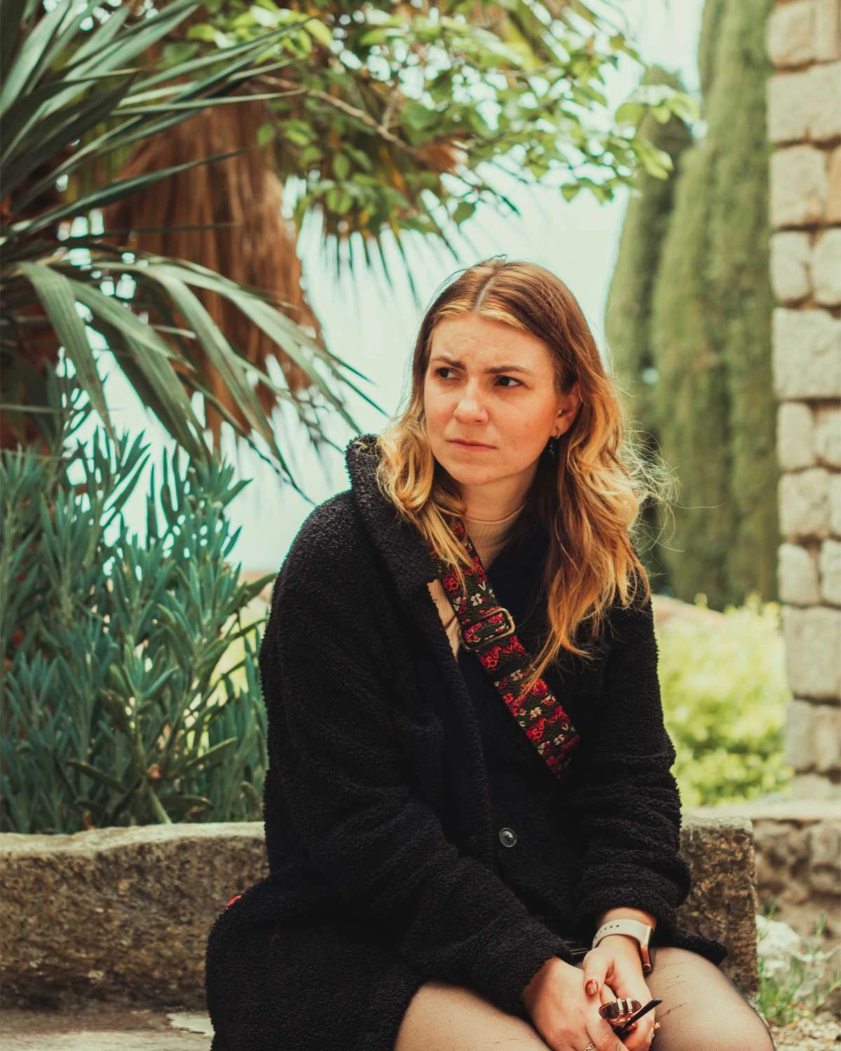 Woman sitting in front of the Meditteranean Sea in Eze, France.